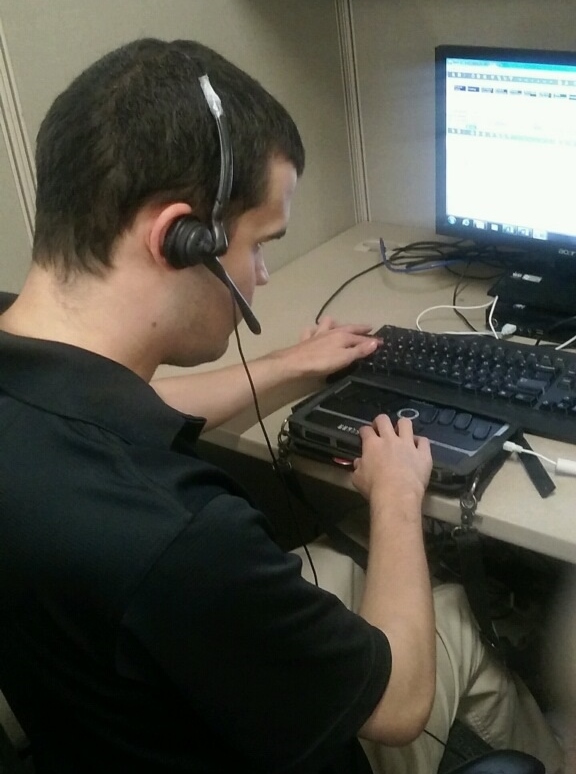 Noah at one of his early jobs, using traditional and assistive technology.